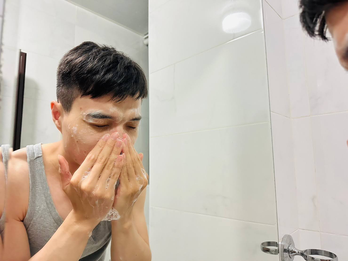 Dora & Rocky 食不湘瞞拍攝爸爸在浴室鏡子前使用薇霓肌本胺基酸調理潔膚露的細緻泡沫清潔臉部肌膚