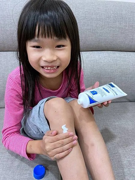 這是一張以兒童為主角的VANICREAM薇霓肌本全日高效修護保濕乳霜使用情境照，旨在推廣該產品的溫和特性和適用於兒童肌膚的定位。小女孩開心的表情也增加了產品的親和力。