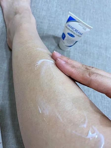 這是一張展示VANICREAM薇霓肌本無油安膚清爽調理乳液旅行瓶被塗抹在腿上的照片，突顯了產品的使用情境。