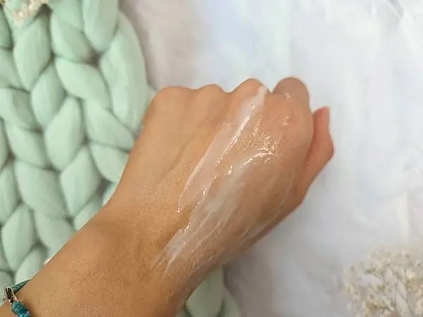VANICREAM薇霓肌本無油安膚清爽調理乳液旅行瓶被塗抹在手背上，呈現出被推開的條狀痕跡，部分區域較厚，部分區域較薄，呈現出濕潤的光澤。