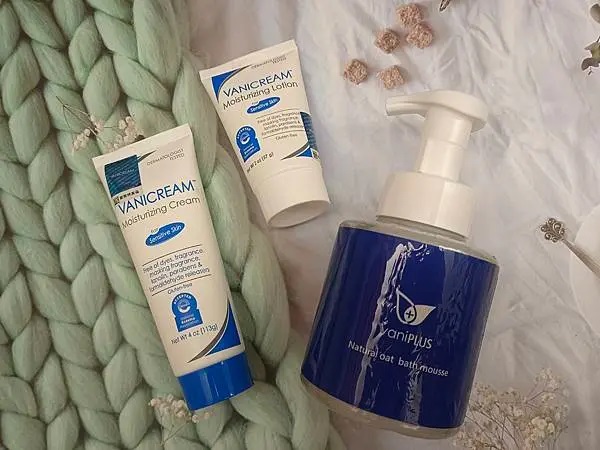 這張照片展示了三款護膚產品：vaniPLUS薇霓進階天然燕麥潔膚慕斯、VANICREAM薇霓肌本全日高效修護保濕乳霜和薇霓肌本無油安膚清爽調理乳液旅行瓶，以及一些裝飾物。