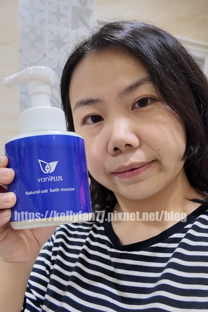 這張自拍照清晰地展示了使用者分享vaniPLUS薇霓進階天然燕麥潔膚慕斯的情景。她微笑的表情和手中展示的沐浴慕斯，傳達了對產品的喜愛和推薦。