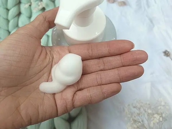 這是一張展示vaniPLUS薇霓進階天然燕麥潔膚慕斯使用效果的照片，突顯其慕斯狀的質地和易於使用的按壓式設計，以及其溫和、自然的形象。