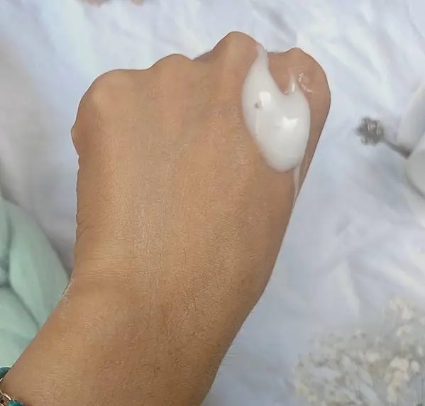 照片以較近的距離拍攝，將焦點集中在手部和VANICREAM薇霓肌本無油安膚清爽調理乳液旅行瓶乳狀質地。