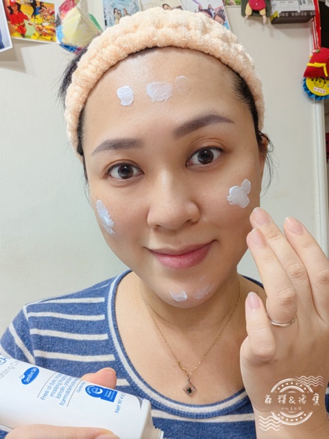 女性使用薇霓肌本全日高效修護保濕乳霜於臉部五點點塗，手持產品瓶身，臉上表情自然，背景為居家環境