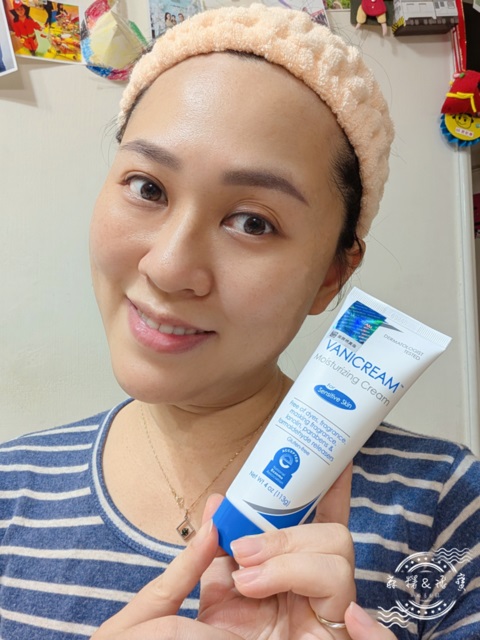 女性手持薇霓肌本全日高效修護保濕乳霜，露出微笑與穩定膚況，背景為居家牆面與照片牆