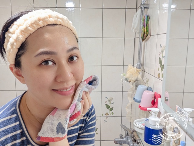 女性使用完vaniplus薇霓進階天然燕麥潔膚慕斯後，微笑以毛巾輕壓臉部拭乾水分，背景可見產品瓶身與浴室環境
